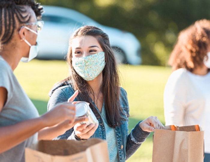 people wearing masks handing out food