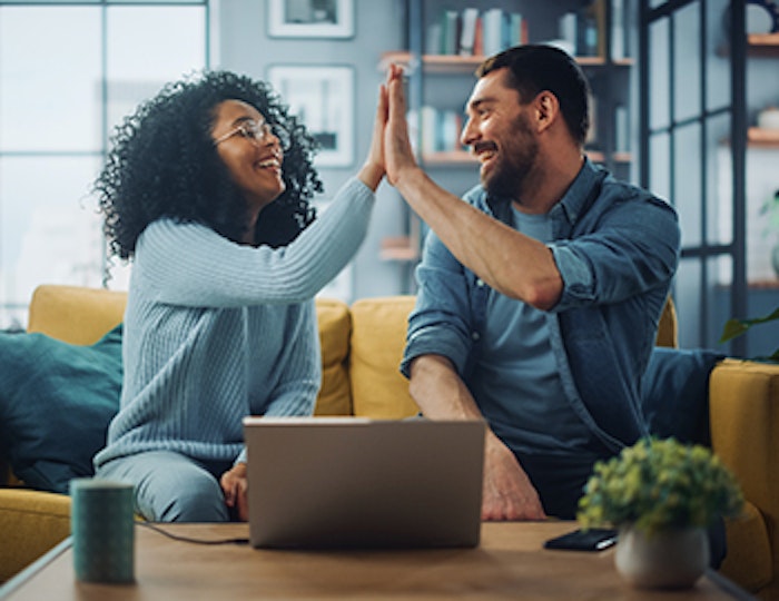 a couple reviewing a computer screen and high fiving