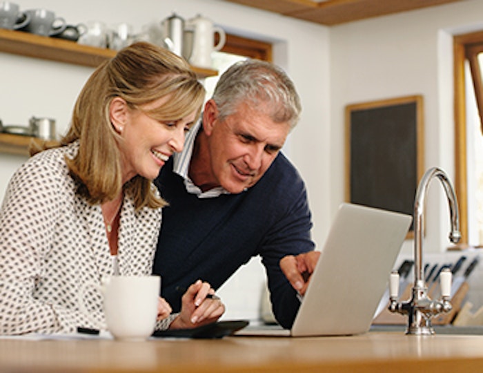 a couple smiling and looking at a computer