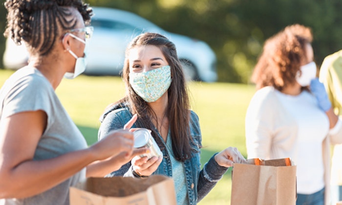 people wearing masks handing out food